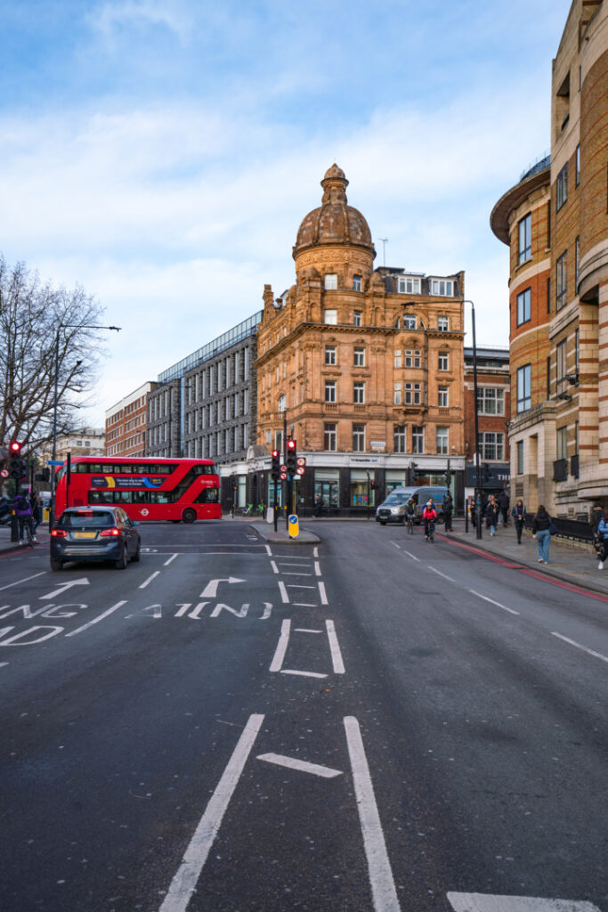 EC English London school building in the Angel district, located on a central London street with the city's iconic red double-decker bus passing by.
