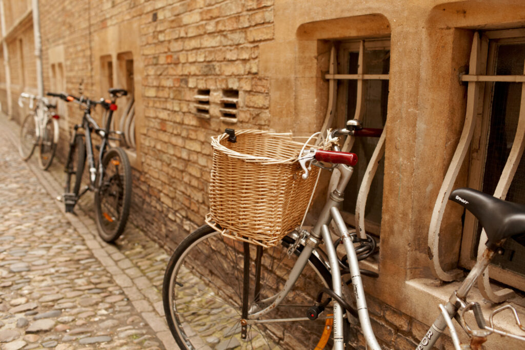 Biciclette parcheggiate lungo una storica strada di Cambridge, simbolo della cultura ciclistica della città.