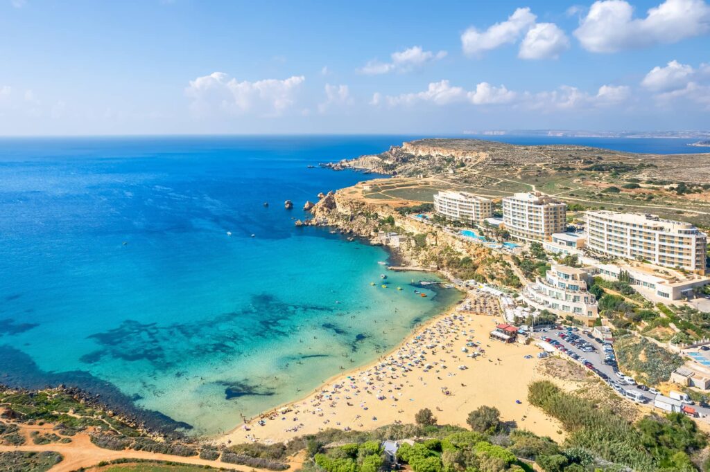 La spiaggia di Golden Bay a Malta con sabbia dorata, acque cristalline del Mediterraneo e suggestive scogliere costiere.