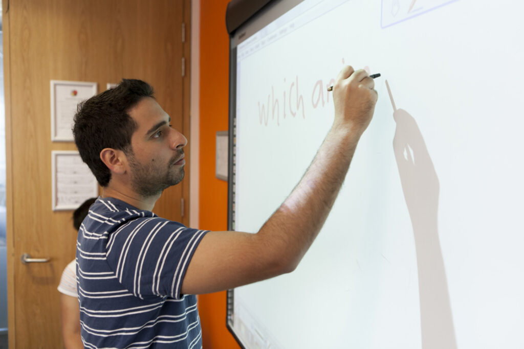 Studente che partecipa a una lezione interattiva di inglese in aula presso EC English Brighton.