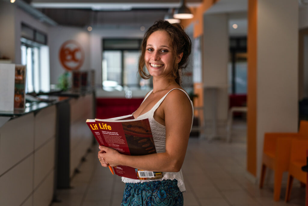 Studente con un libro di testo all’ingresso della scuola
